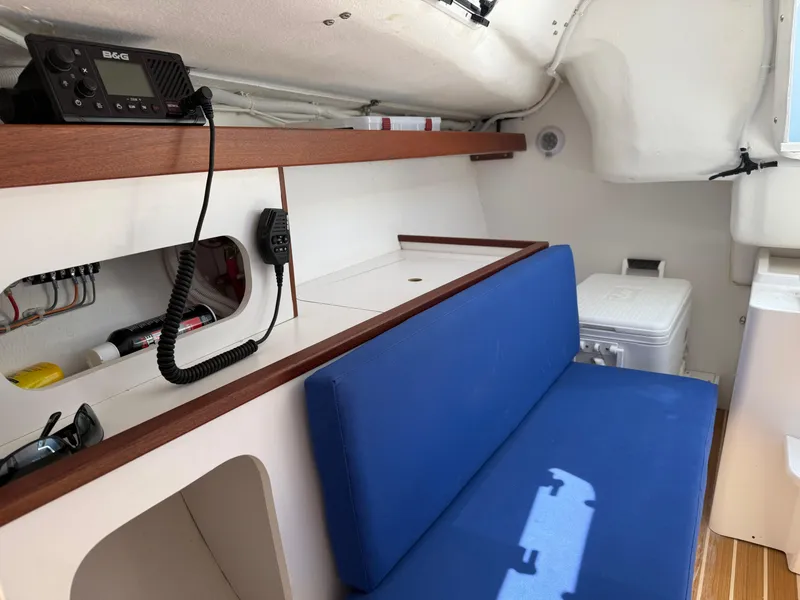 Slide: The Image of 2022 J Boats J/9 interior with blue seating, radio, and storage compartments. - 45