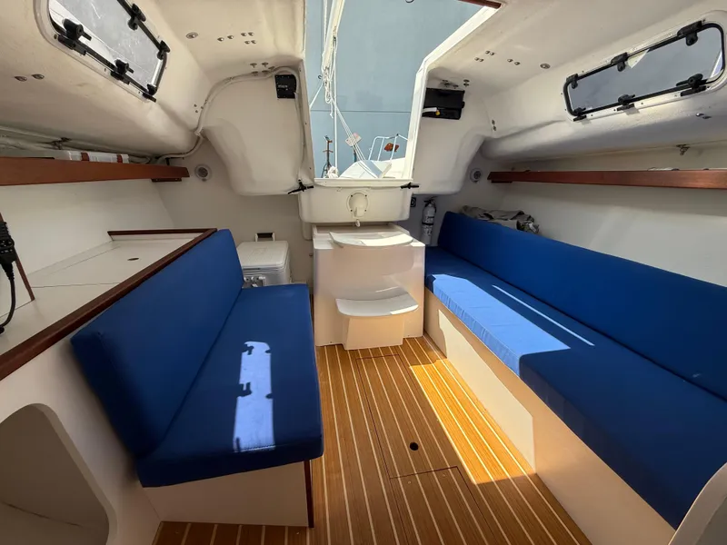Slide: The Image of Interior of 2022 J Boats J/9 sailboat with blue seating and wooden flooring. - 46