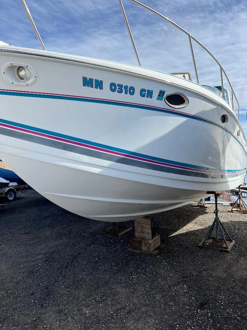 Slide: The Image of 1994 Formula 31 PC boat on stands, white hull with blue and pink stripes. - 16