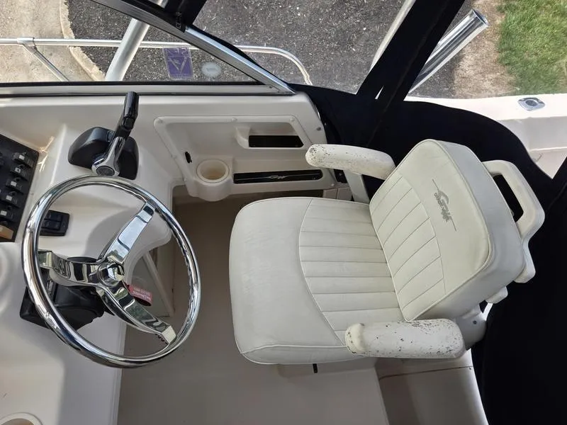 Slide: The Image of 2007 Grady-White 232 Gulfstream boat cockpit with steering wheel and white captain's chair. - 11