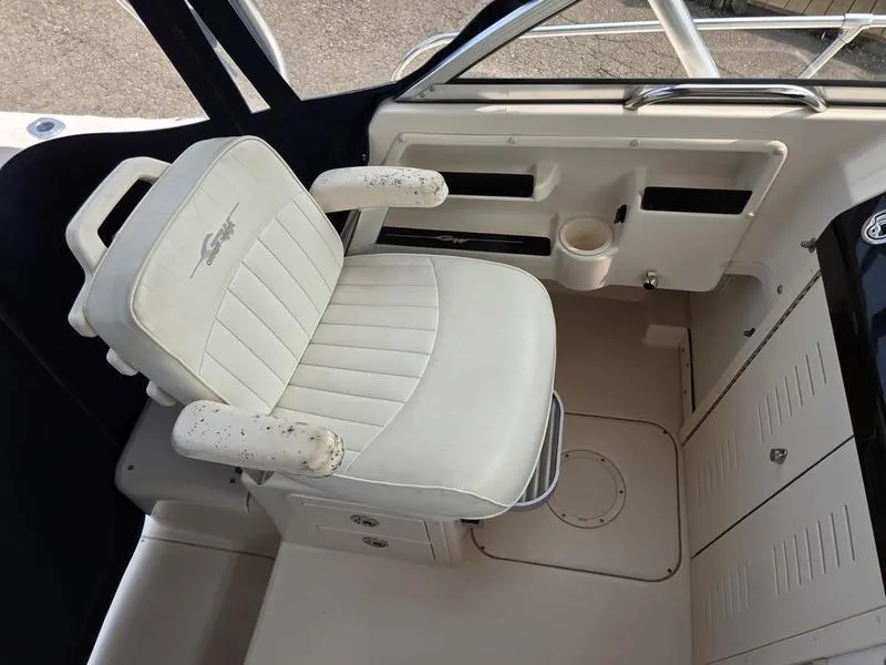Slide: The Image of Captain's seat in 2007 Grady-White 232 Gulfstream boat cockpit, featuring white upholstery. - 13