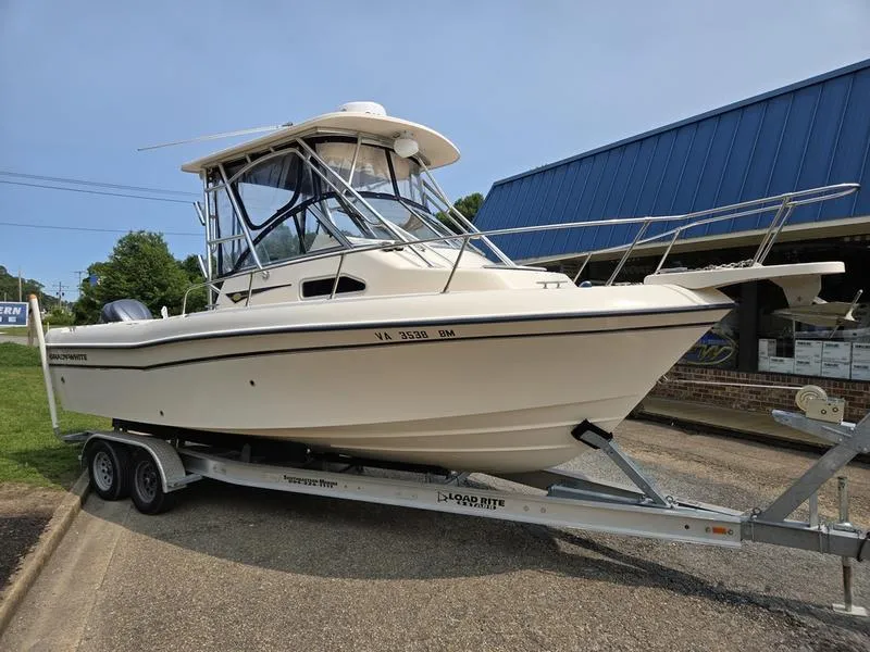 Slide: The Image of 2007 Grady-White 232 Gulfstream boat on trailer, parked outdoors near a blue building. - 25