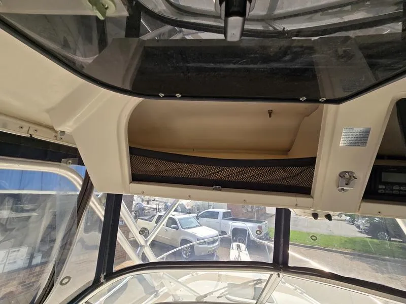 Slide: The Image of 2007 Grady-White 232 Gulfstream boat interior with storage compartment and windshield view. - 27