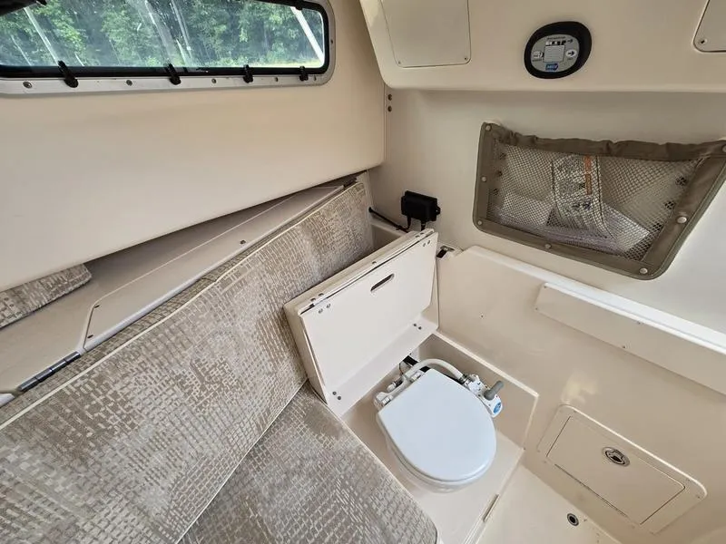 Slide: The Image of 2007 Grady-White 232 Gulfstream cabin interior with seating and compact marine toilet. - 29