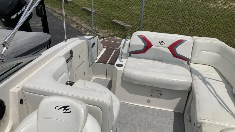 Slide: The Image of 2010 Monterey M5 Sport Boat interior with white seating and logo accents. - 2