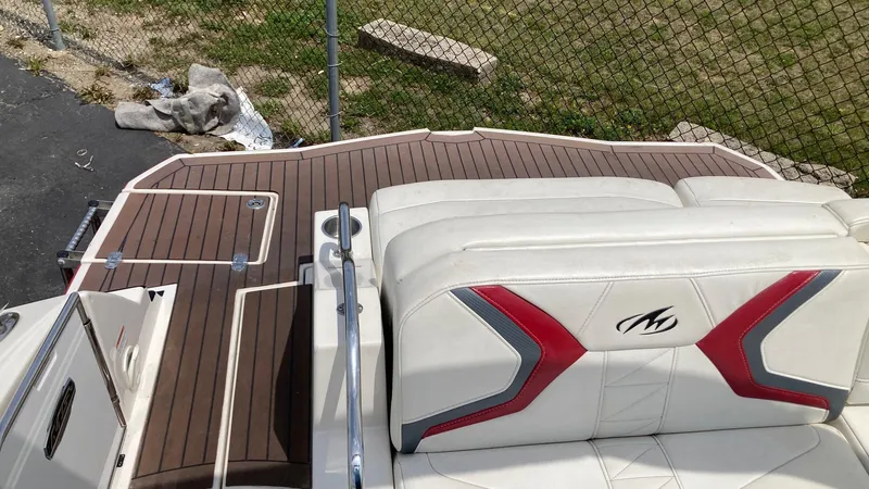 Slide: The Image of 2010 Monterey M5 Sport Boat with white and red seating, wooden deck, and metal railing. - 4