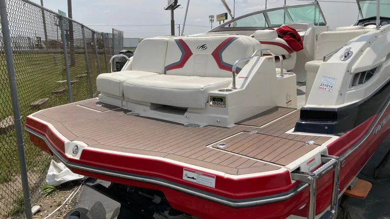 Slide: The Image of 2010 Monterey M5 Sport Boat with red and white seating, docked near a fence. - 5