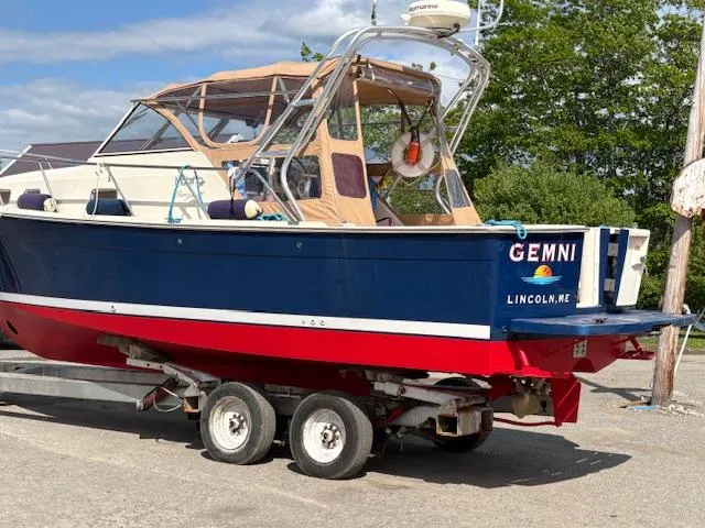 Slide: The Image of 2005 Mainship 30 Pilot Rum Runner boat on trailer, blue and red hull, docked outdoors. - 10