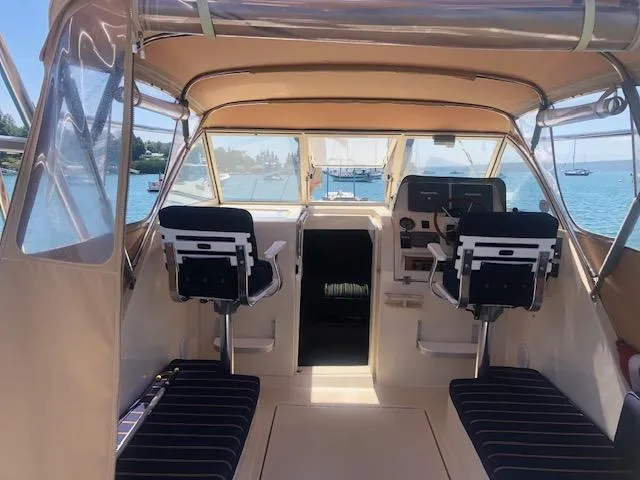 Slide: The Image of 2005 Mainship 30 Pilot Rum Runner interior with helm, seating, and ocean view. - 2