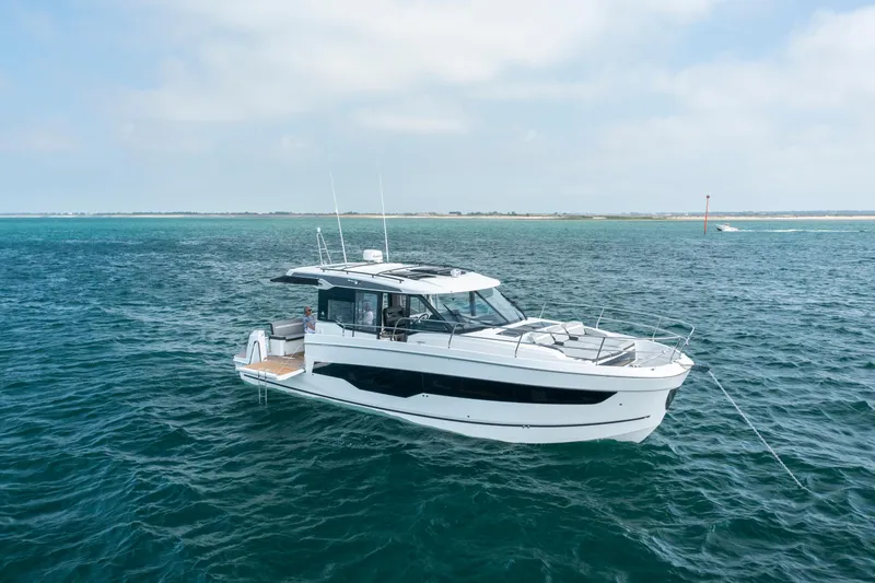 The Image of 2026 Jeanneau NC1295 Coupe yacht cruising on open water. - 1