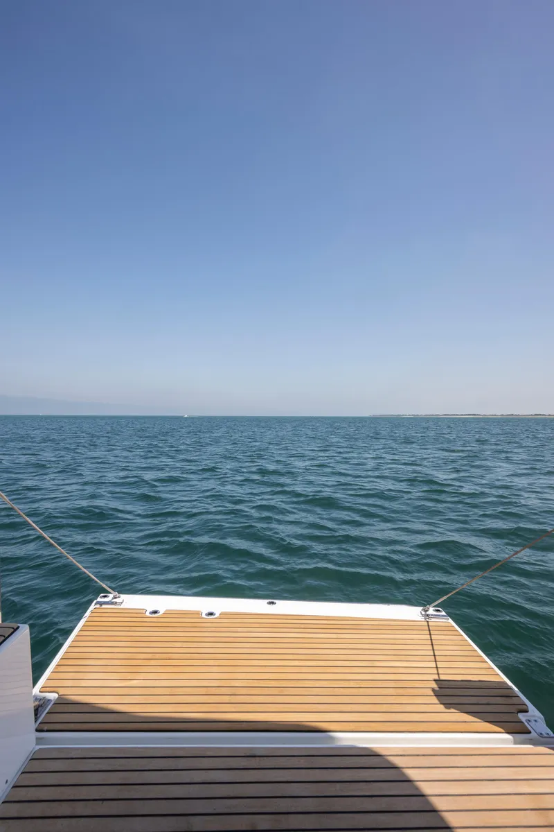 Slide: The Image of 2026 Jeanneau NC1295 Coupe boat deck overlooking calm ocean waters. - 12