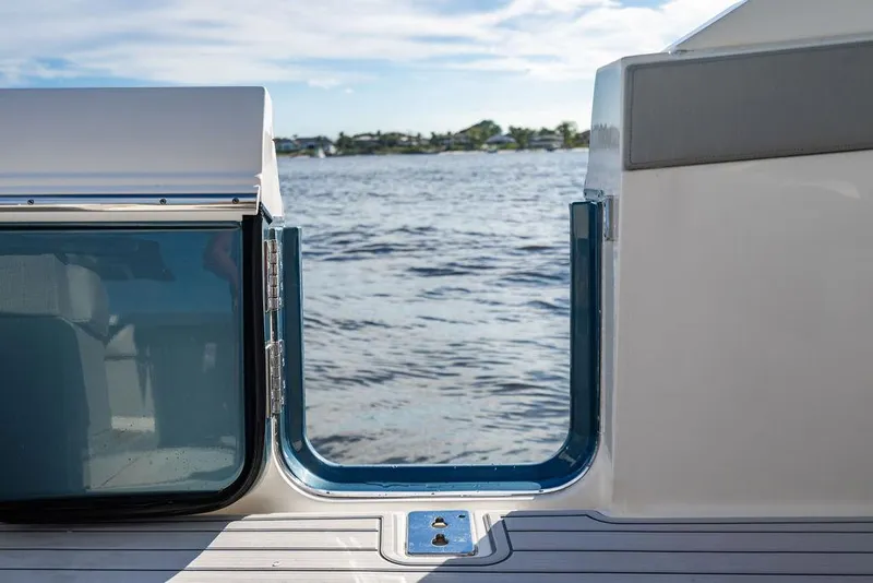 Slide: The Image of 2022 Tiara Yachts 43 LS yacht with open side door, overlooking serene water. - 10