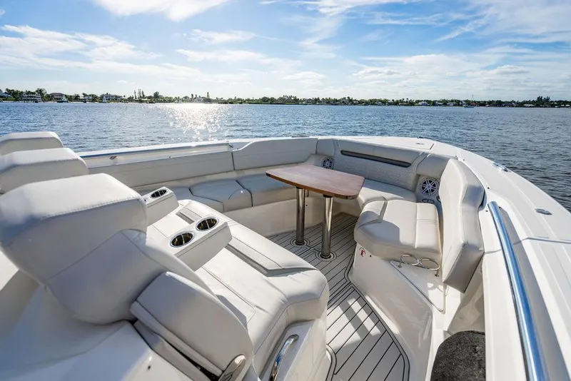Slide: The Image of 2022 Tiara Yachts 43 LS boat interior with seating and table, overlooking a serene water view. - 18