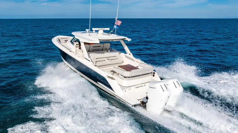 Slide: The Image of 2022 Tiara Yachts 43 LS cruising on open ocean with American flag. - 2