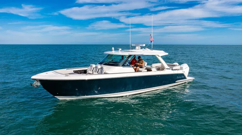 Slide: The Image of 2022 Tiara Yachts 43 LS cruising on open water under a clear blue sky. - 26
