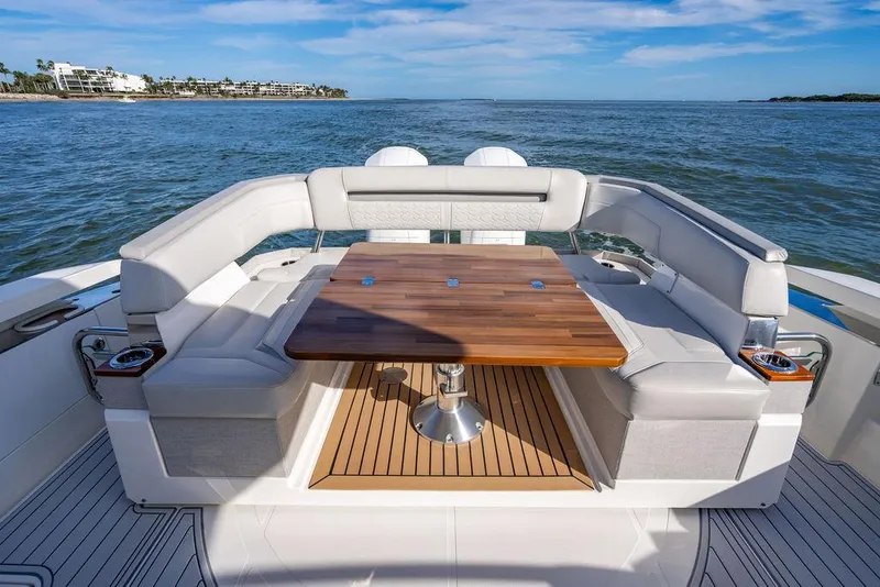 Slide: The Image of 2022 Tiara Yachts 43 LS luxury boat with elegant seating and wooden table on open water. - 6