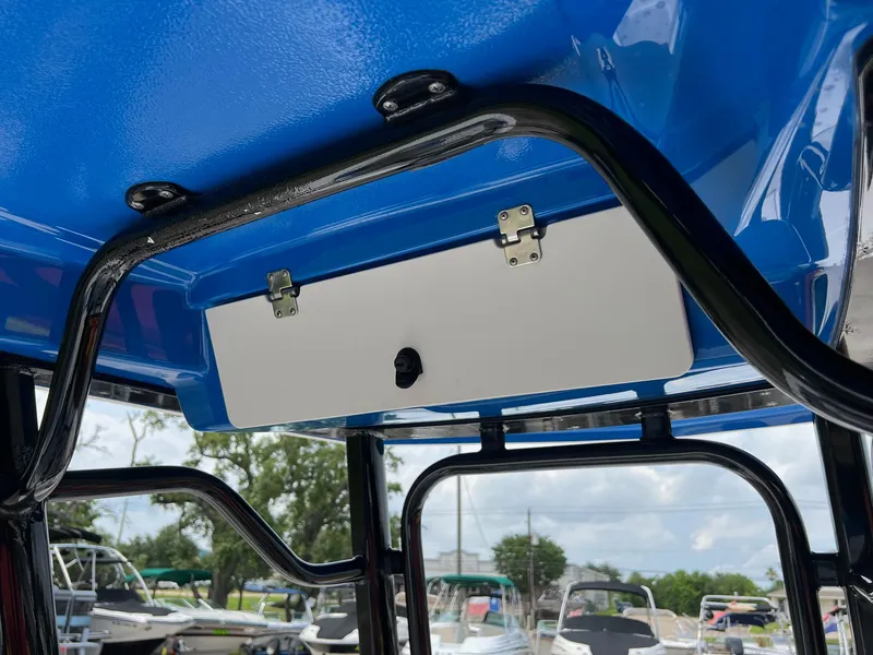 Slide: The Image of 2018 Robalo 246 Cayman boat with blue canopy and storage compartment. - 21