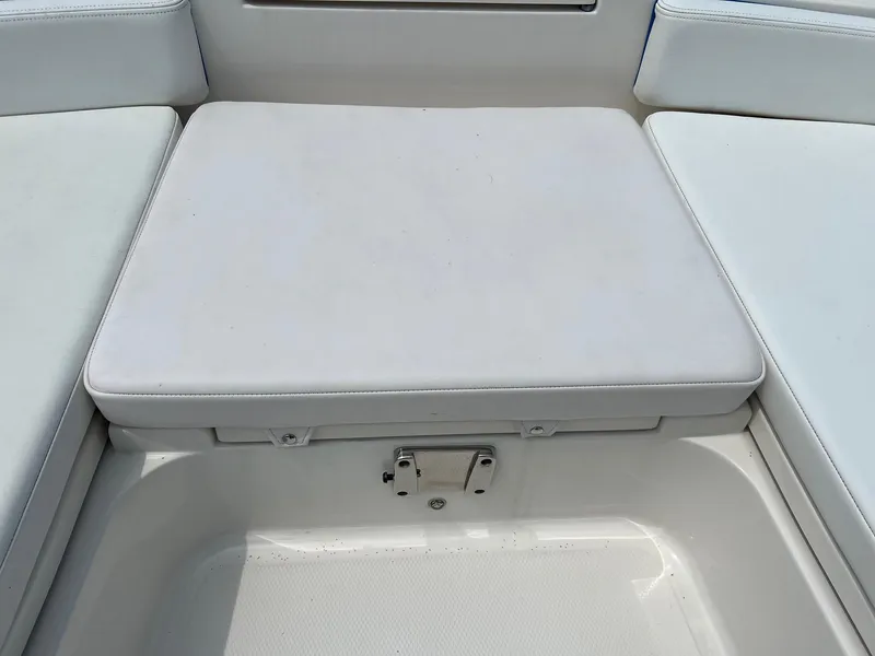 Slide: The Image of 2018 Robalo 246 Cayman boat seating area with white cushioned seat. - 25