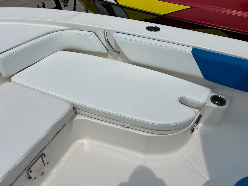 Slide: The Image of 2018 Robalo 246 Cayman boat seating area with white cushions and cup holder. - 29