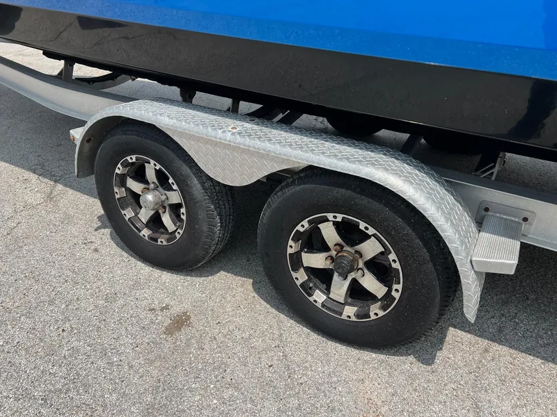 Slide: The Image of Trailer wheels of a 2018 Robalo 246 Cayman boat on pavement. - 3