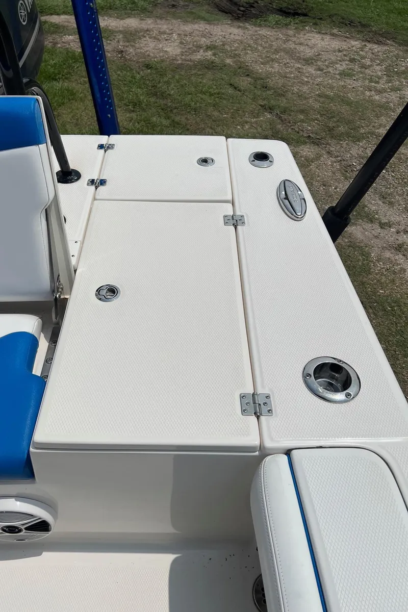 Slide: The Image of 2018 Robalo 246 Cayman boat deck with blue seating and storage compartments. - 33