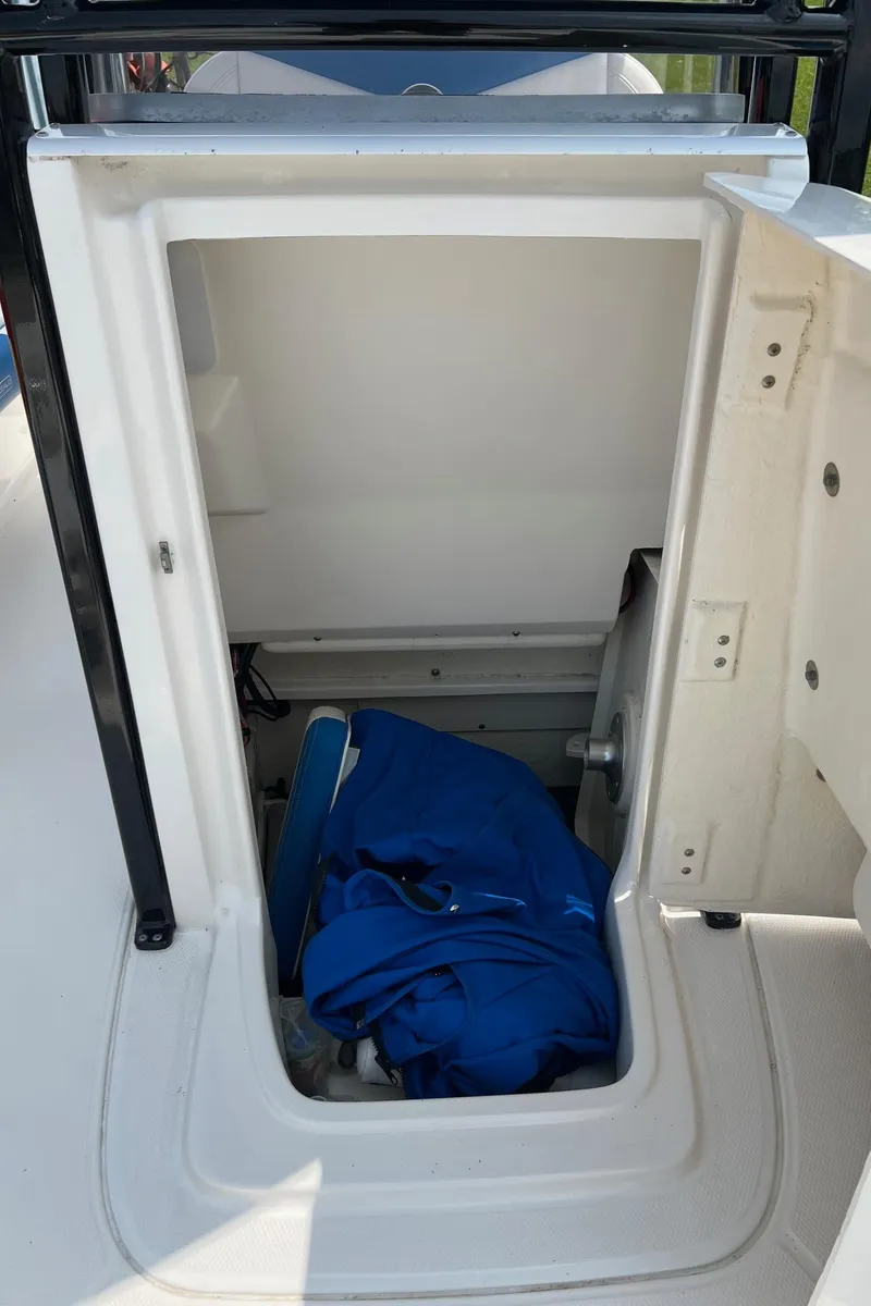 Slide: The Image of 2018 Robalo 246 Cayman storage compartment with blue fabric inside. - 35
