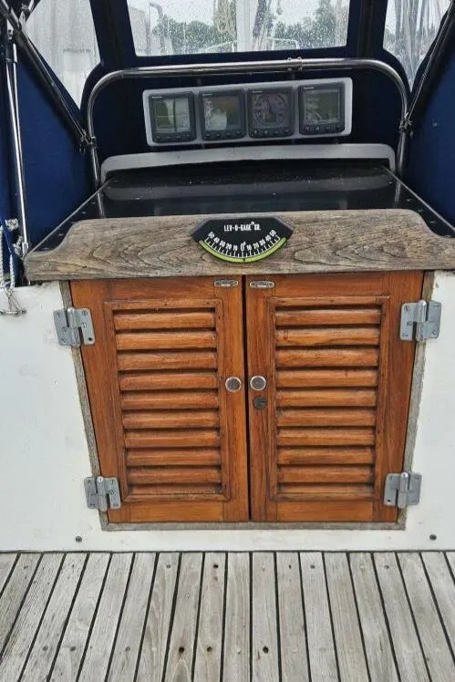 Slide: The Image of 1983 Cheoy Lee Pedrick 41 yacht cockpit with wooden cabinets and navigation instruments. - 23