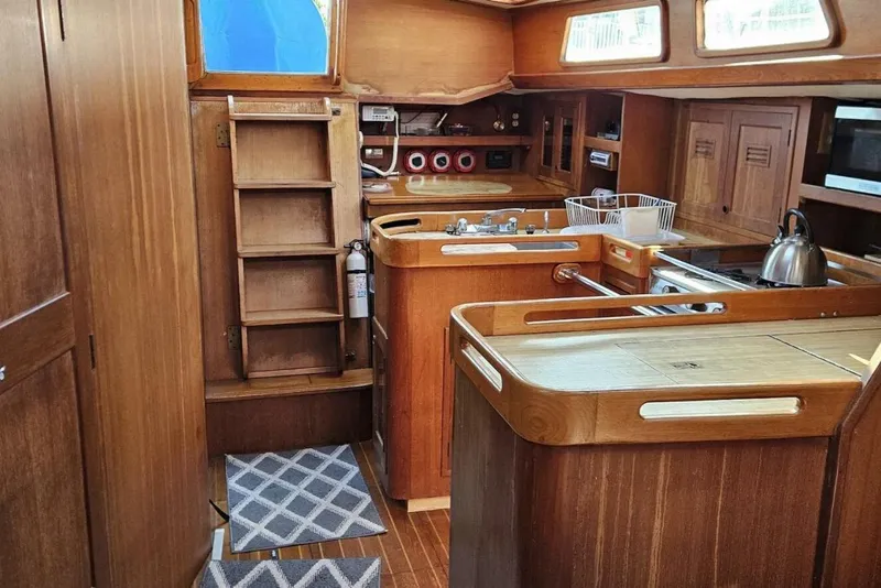Slide: The Image of Interior of 1983 Cheoy Lee Pedrick 41 sailboat with wooden cabinetry and kitchen area. - 25