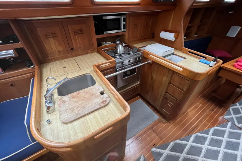 Slide: The Image of 1983 Cheoy Lee Pedrick 41 yacht interior kitchen with wooden cabinetry and modern appliances. - 32