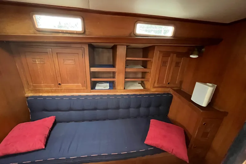Slide: The Image of Interior of 1983 Cheoy Lee Pedrick 41 yacht with wooden cabinets and blue cushioned seating. - 41