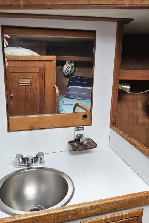 Slide: The Image of 1983 Cheoy Lee Pedrick 41 yacht interior with sink, mirror, and wooden cabinetry. - 47