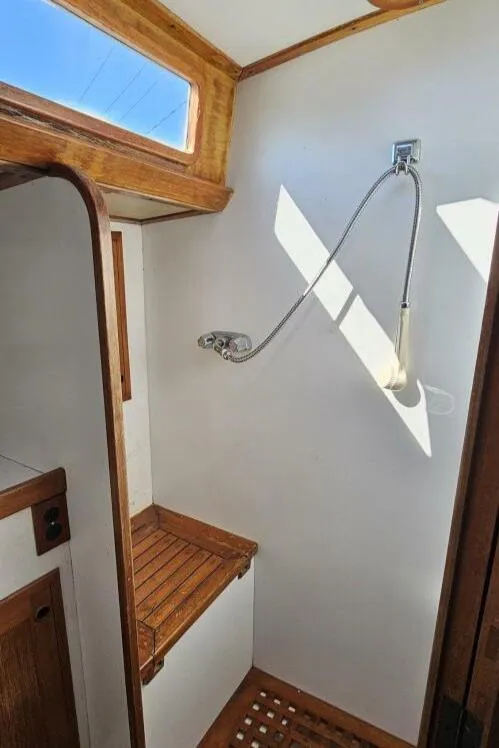 Slide: The Image of 1983 Cheoy Lee Pedrick 41 yacht interior shower with wooden accents and natural light. - 48