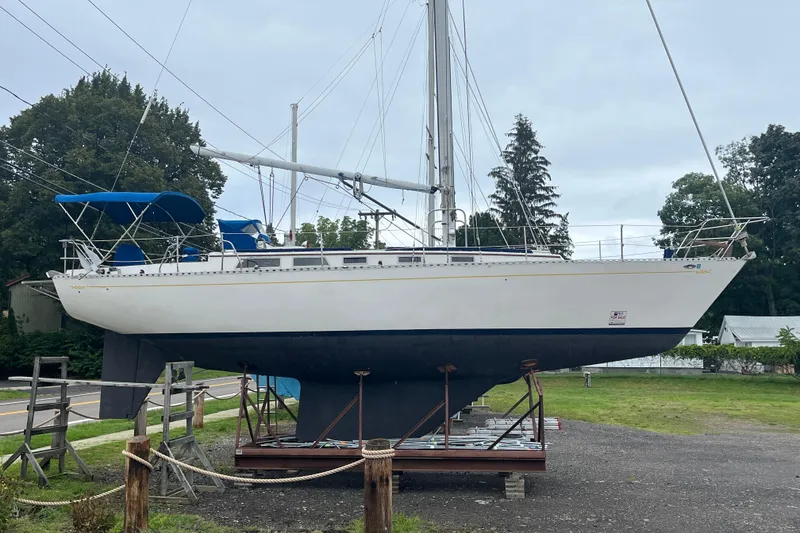 Slide: The Image of 1983 Cheoy Lee Pedrick 41 sailboat on display, elevated on supports, with blue canopy. - 9