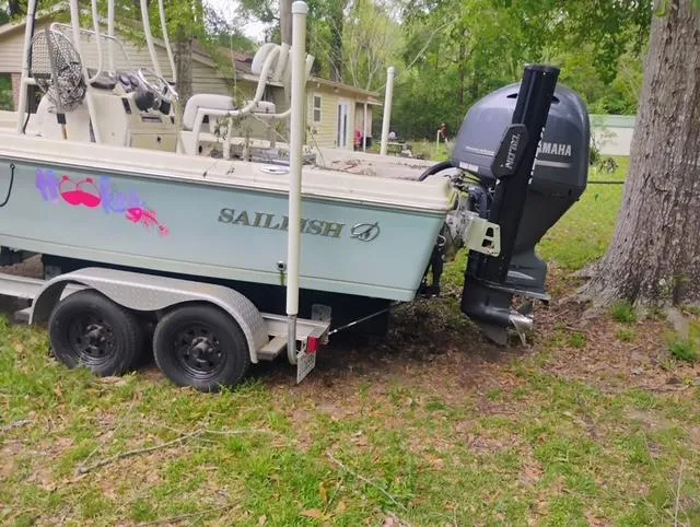Slide: The Image of 2017 Sailfish 2100 BB Bay Boat on trailer with Yamaha outboard motor, parked on grass. - 10