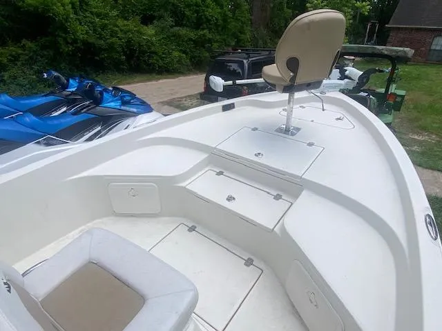 Slide: The Image of 2017 Sailfish 2100 BB Bay Boat with seating and storage, parked near greenery and vehicles. - 15