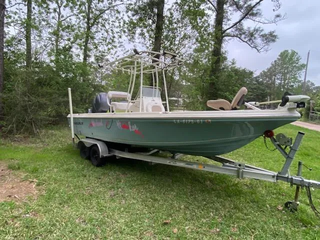 Slide: The Image of 2017 Sailfish 2100 BB Bay Boat on trailer, parked on grass, surrounded by trees. - 8