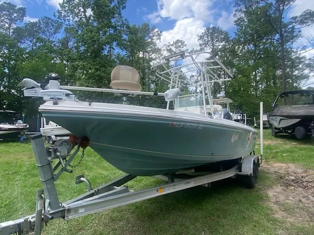 Slide: The Image of 2017 Sailfish 2100 BB Bay Boat on trailer, parked on grass with trees in background. - 9