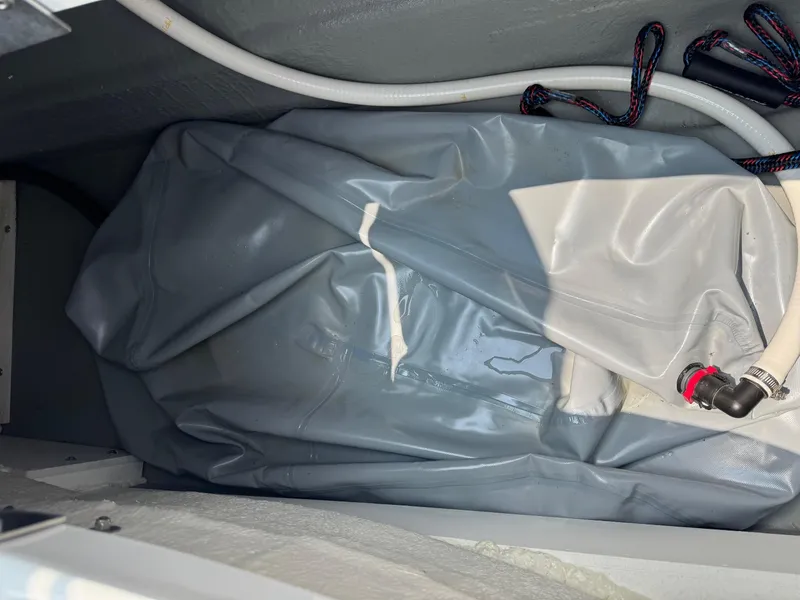 Slide: The Image of Storage compartment of 2023 Crownline 280 SS SURF boat with hoses and wiring. - 14