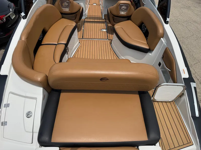 Slide: The Image of 2023 Crownline 280 SS SURF boat interior with tan leather seating and wood flooring. - 5