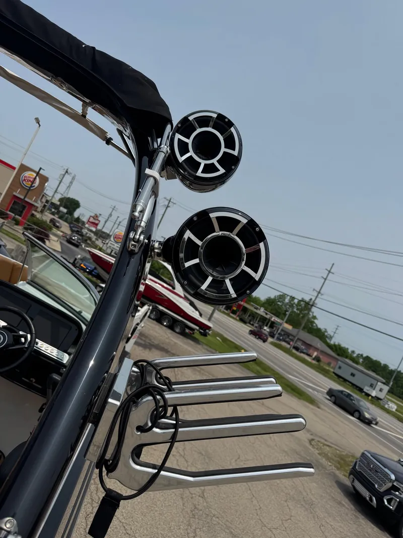 Slide: The Image of 2023 Crownline 280 SS SURF boat speakers and wakeboard racks in a parking lot. - 6