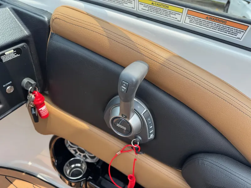 Slide: The Image of Throttle control of 2023 Crownline 280 SS SURF boat with safety lanyard and warning labels. - 9