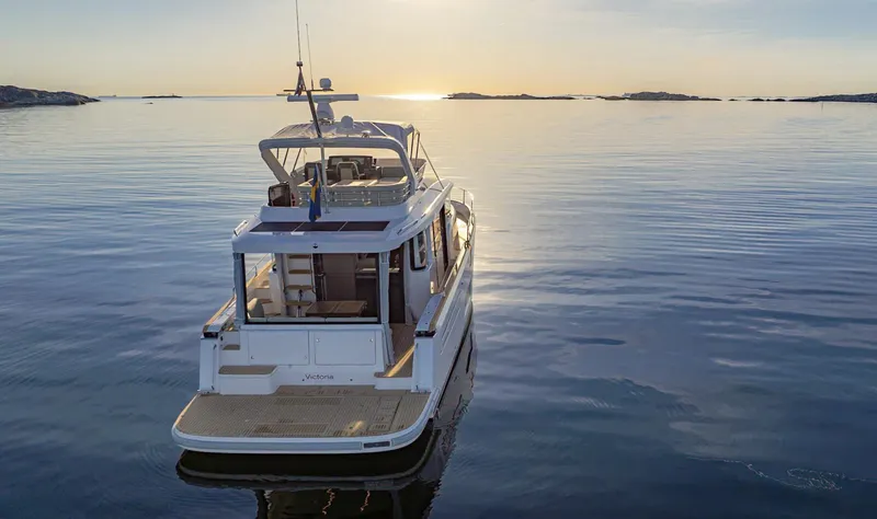 Slide: The Image of 2025 Nimbus 495 Flybridge yacht on calm water at sunset. - 33