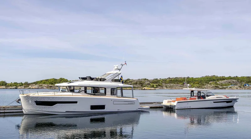 Slide: The Image of 2025 Nimbus 495 Flybridge yacht docked on calm water, scenic background. - 37