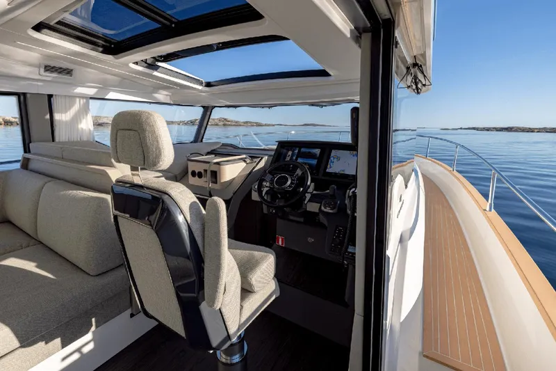 Slide: The Image of Interior of 2025 Nimbus 495 Flybridge yacht with modern helm and panoramic views. - 9