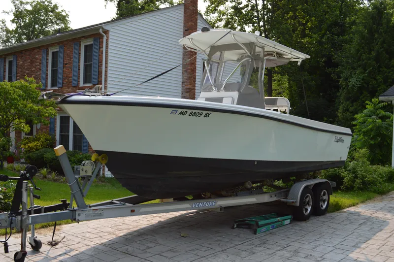 Slide: The Image of 2007 Edgewater 228CC boat on trailer, parked in residential driveway. - 2