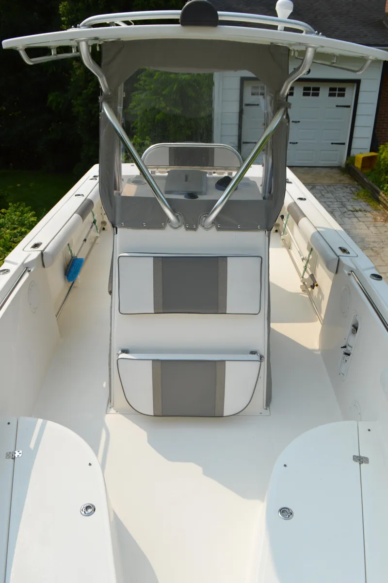 Slide: The Image of 2007 Edgewater 228CC boat interior with seating and console, parked near a garage. - 23