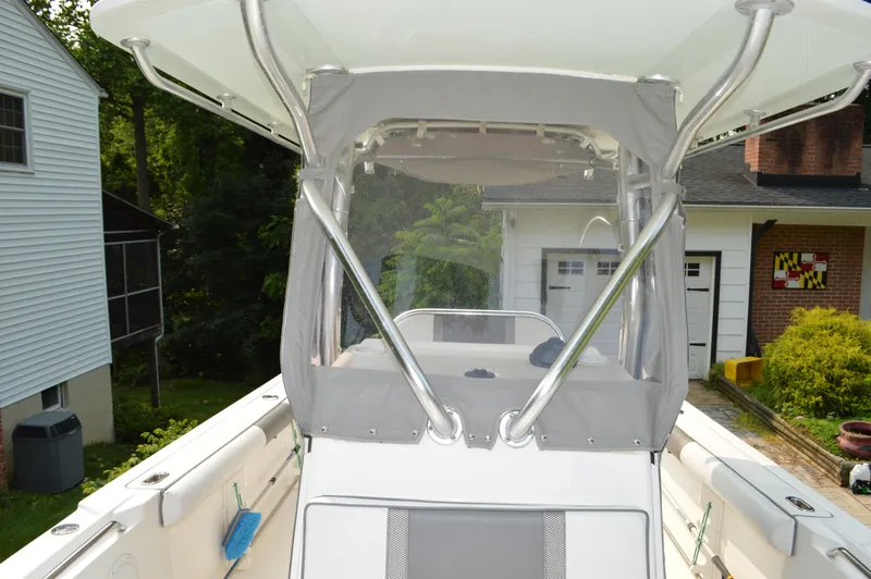 Slide: The Image of 2007 Edgewater 228CC boat with canopy, parked in a residential driveway. - 24