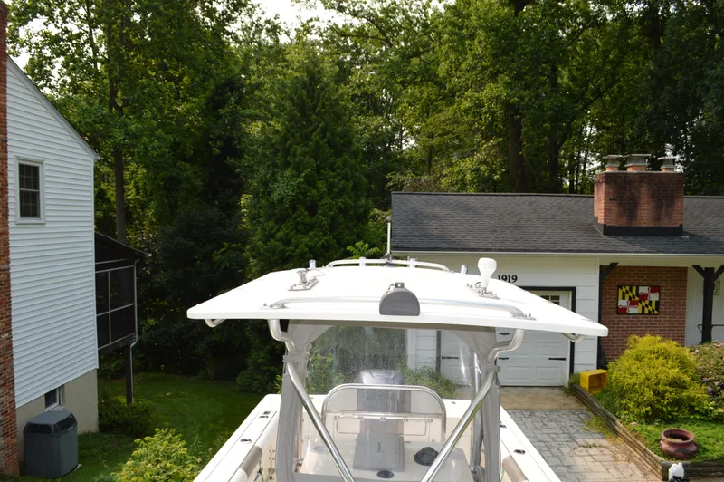 Slide: The Image of Edgewater 228CC boat from 2007 parked in a residential driveway, surrounded by trees. - 25