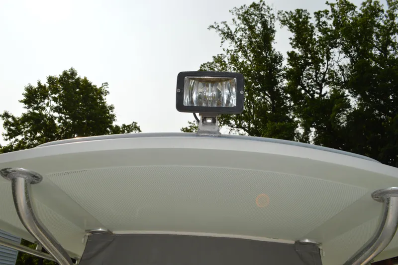 Slide: The Image of 2007 Edgewater 228CC boat spotlight on canopy with trees in background. - 27