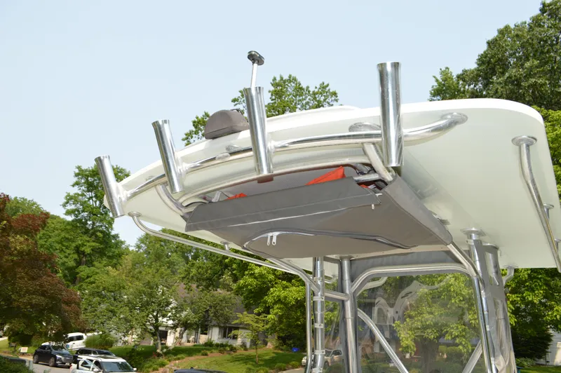 Slide: The Image of Edgewater 228CC 2007 boat with T-top and rod holders, parked outdoors. - 29